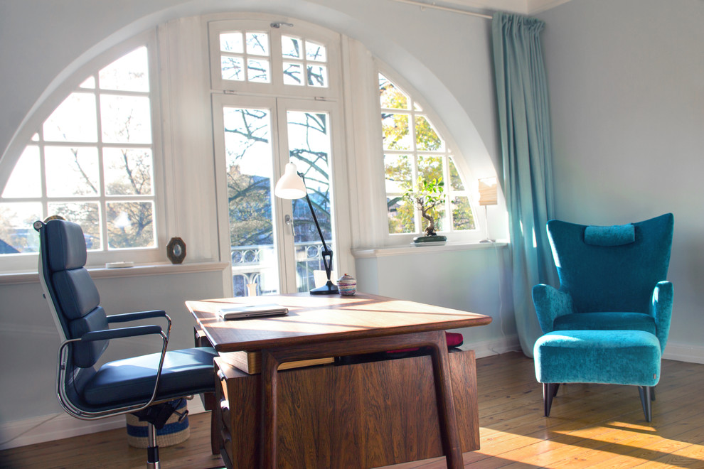 Foto de despacho moderno de tamaño medio con paredes verdes, suelo de madera clara y escritorio independiente