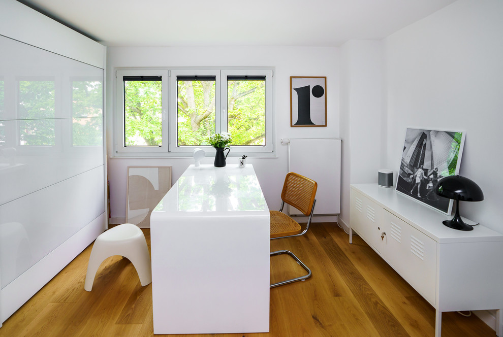 フランクフルトにある広いコンテンポラリースタイルのおしゃれな書斎 (白い壁、無垢フローリング、暖炉なし、自立型机、茶色い床) の写真