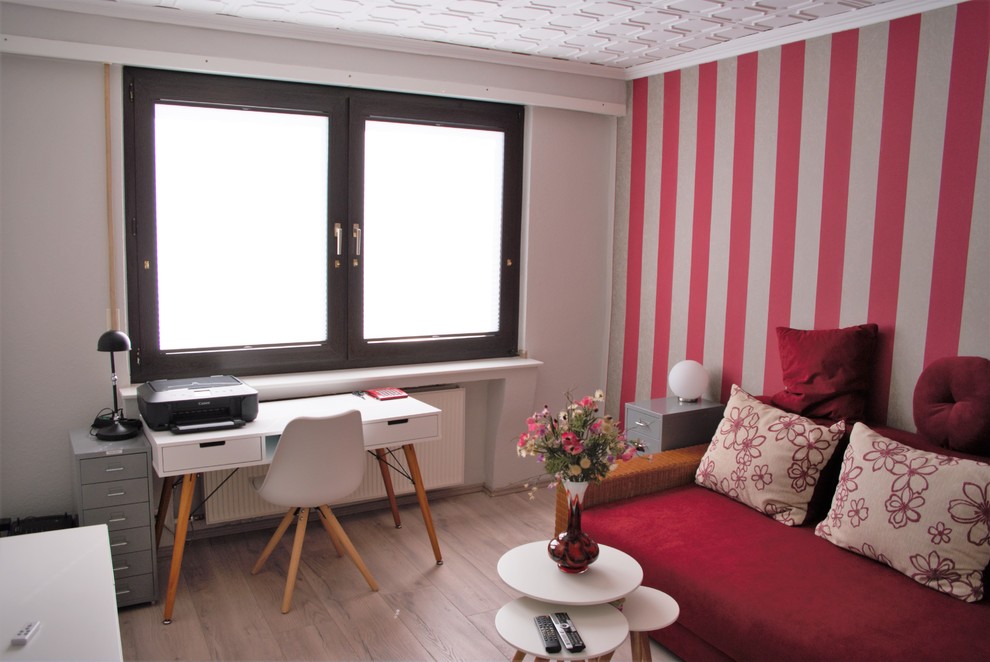 Imagen de estudio escandinavo pequeño con paredes grises, suelo laminado y escritorio independiente