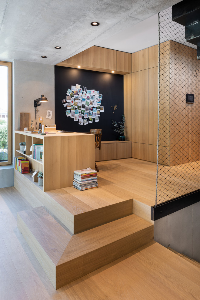 Diseño de despacho escandinavo sin chimenea con suelo de madera clara, escritorio empotrado, paredes grises, suelo beige y madera
