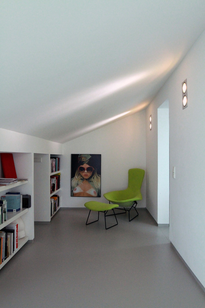 Idee per un piccolo studio minimal con libreria, pareti bianche e pavimento grigio