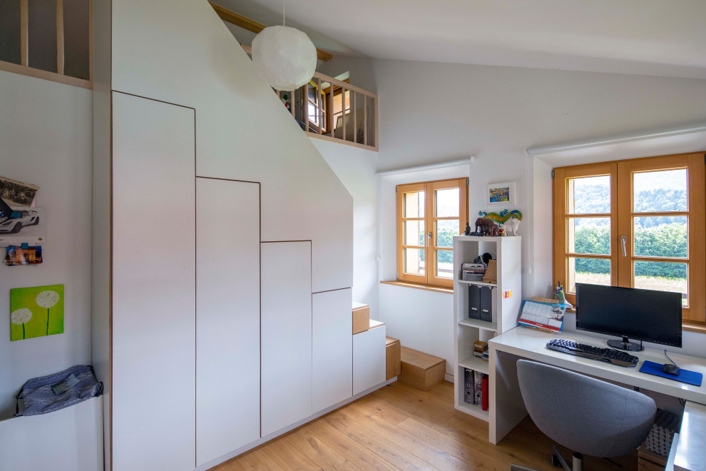 Inspiration för lantliga arbetsrum, med vita väggar, mellanmörkt trägolv, ett fristående skrivbord och brunt golv