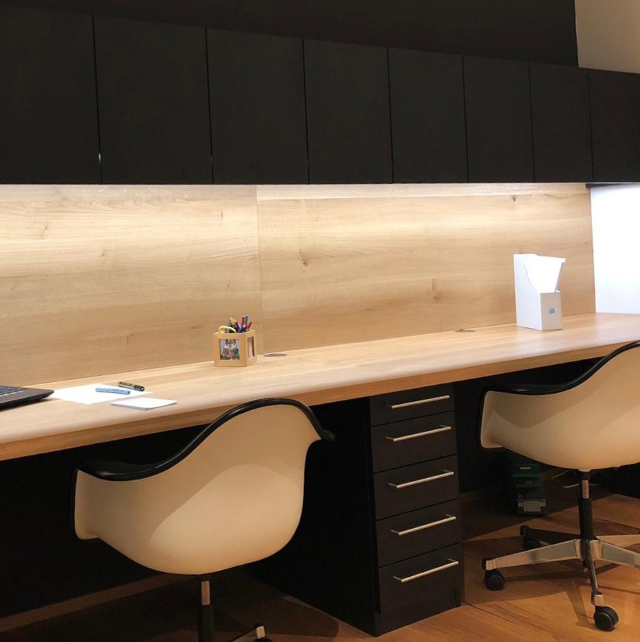 Idee per un ufficio minimal di medie dimensioni con pareti nere, pavimento in legno massello medio, scrivania incassata e pavimento marrone