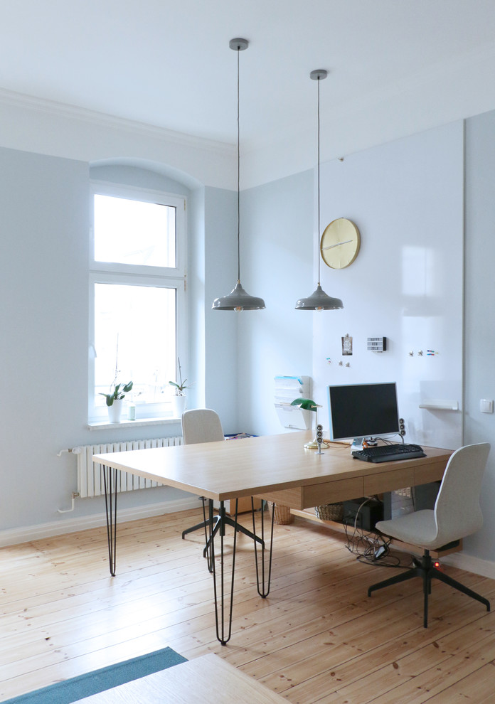 Idee per un grande ufficio scandinavo con pareti blu, parquet chiaro, scrivania incassata, pavimento beige e nessun camino