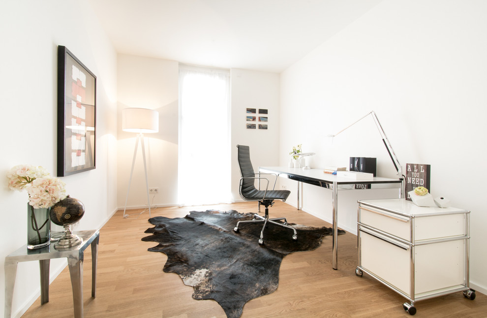 Idee per un ufficio design di medie dimensioni con pareti bianche, scrivania autoportante, pavimento in legno massello medio e nessun camino