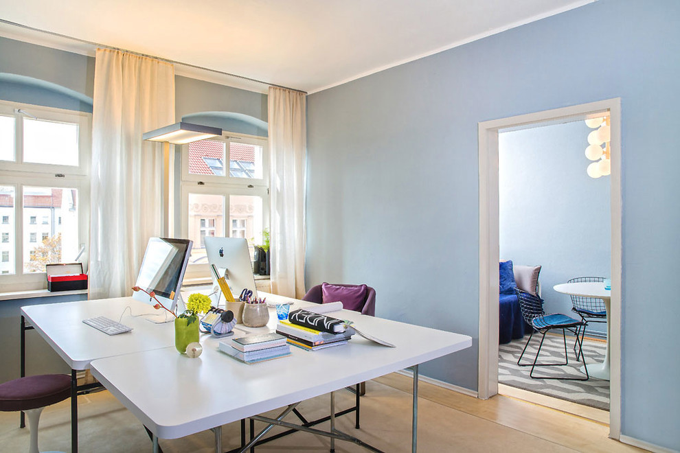 Kleines Mid-Century Arbeitszimmer mit blauer Wandfarbe, Teppichboden und freistehendem Schreibtisch in Berlin