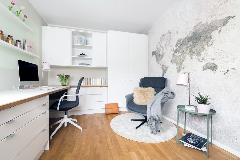 Inredning av ett minimalistiskt mellanstort hemmabibliotek, med ljust trägolv, ett inbyggt skrivbord, beiget golv och beige väggar