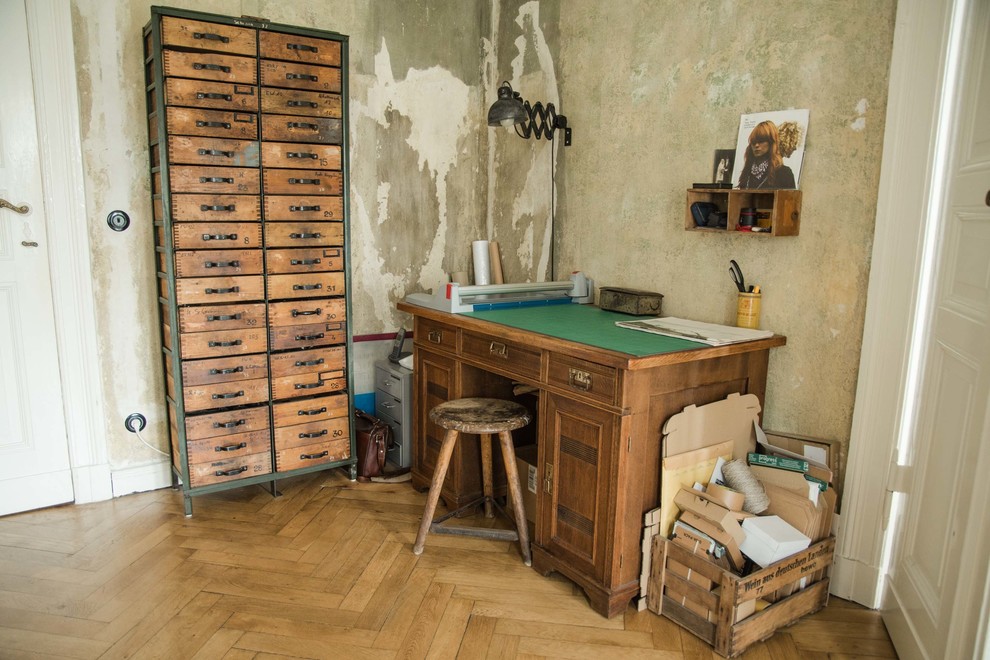 This is an example of a medium sized eclectic study in Berlin with beige walls, medium hardwood flooring, a freestanding desk and no fireplace.