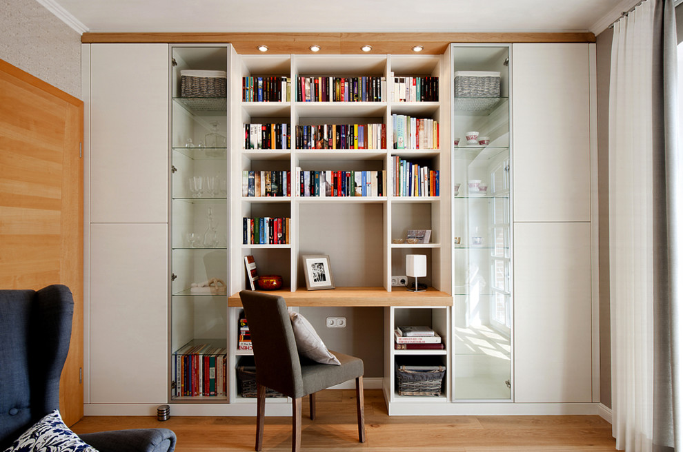 Mittelgroßes Modernes Arbeitszimmer ohne Kamin mit Arbeitsplatz, grauer Wandfarbe, braunem Holzboden und Einbau-Schreibtisch in Sonstige