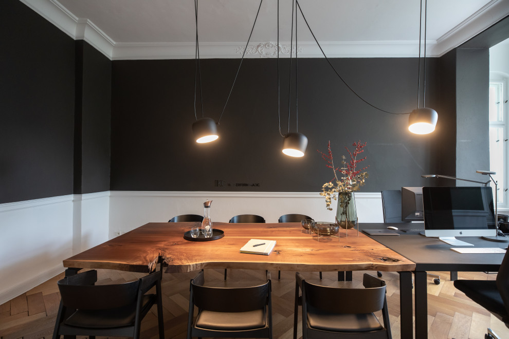 Aménagement d'une salle à manger contemporaine avec un mur noir, un sol en bois brun et un sol marron.
