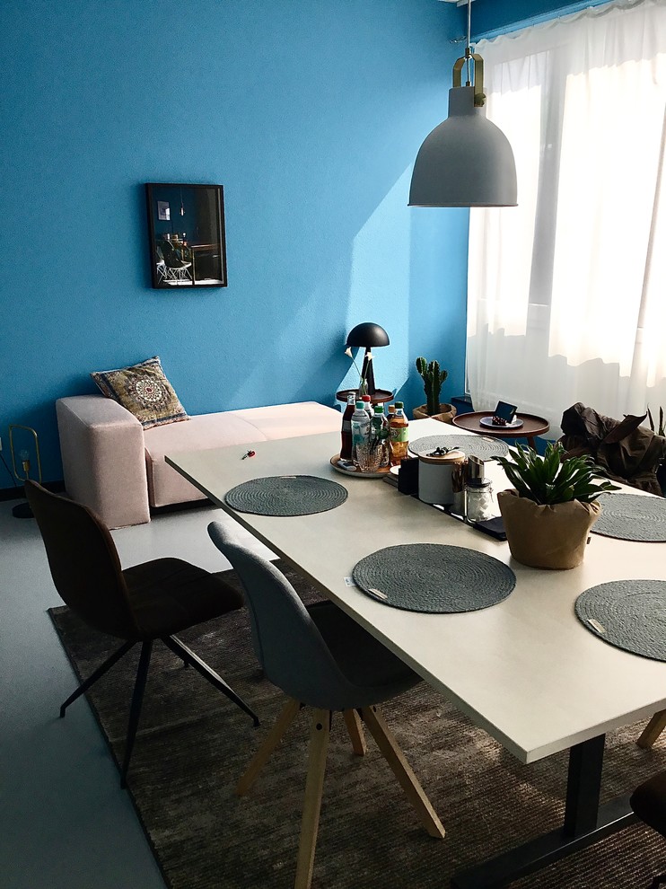 Immagine di un ufficio minimal di medie dimensioni con pareti blu, pavimento in cemento e pavimento grigio