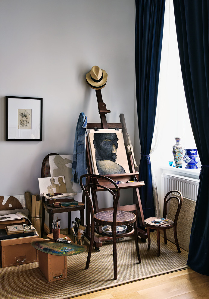 Foto på ett litet eklektiskt hemmastudio, med vita väggar, mellanmörkt trägolv och brunt golv