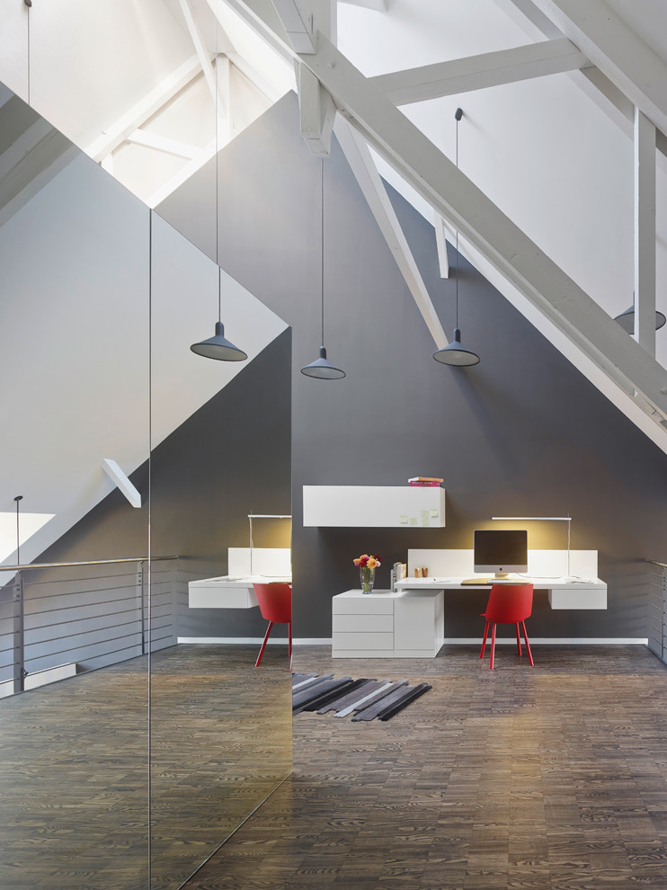 Großes Modernes Arbeitszimmer ohne Kamin mit Arbeitsplatz, grauer Wandfarbe, dunklem Holzboden und Einbau-Schreibtisch in Stuttgart