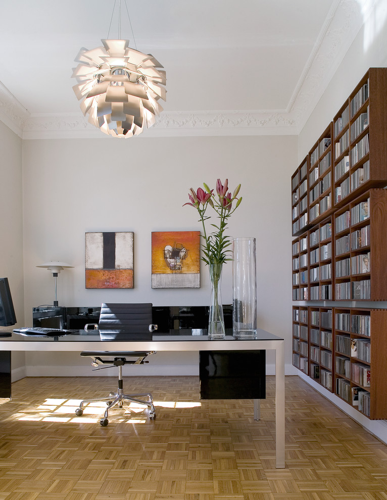 Idéer för ett stort modernt hemmabibliotek, med beige väggar, mellanmörkt trägolv och ett fristående skrivbord