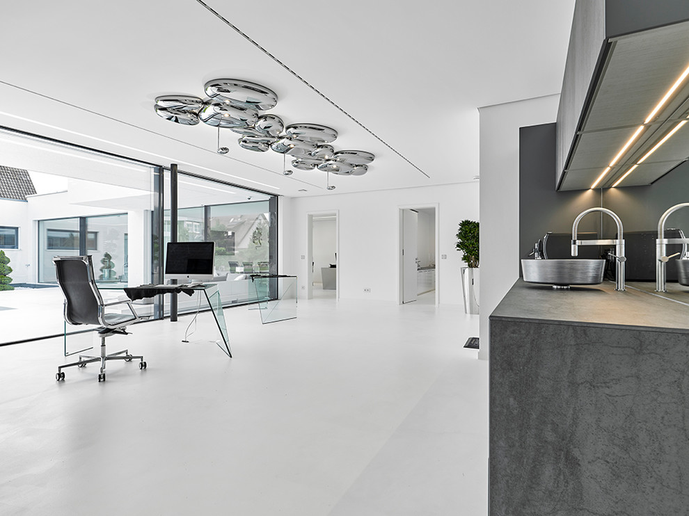 Modernes Arbeitszimmer ohne Kamin mit Arbeitsplatz, weißer Wandfarbe, freistehendem Schreibtisch und weißem Boden