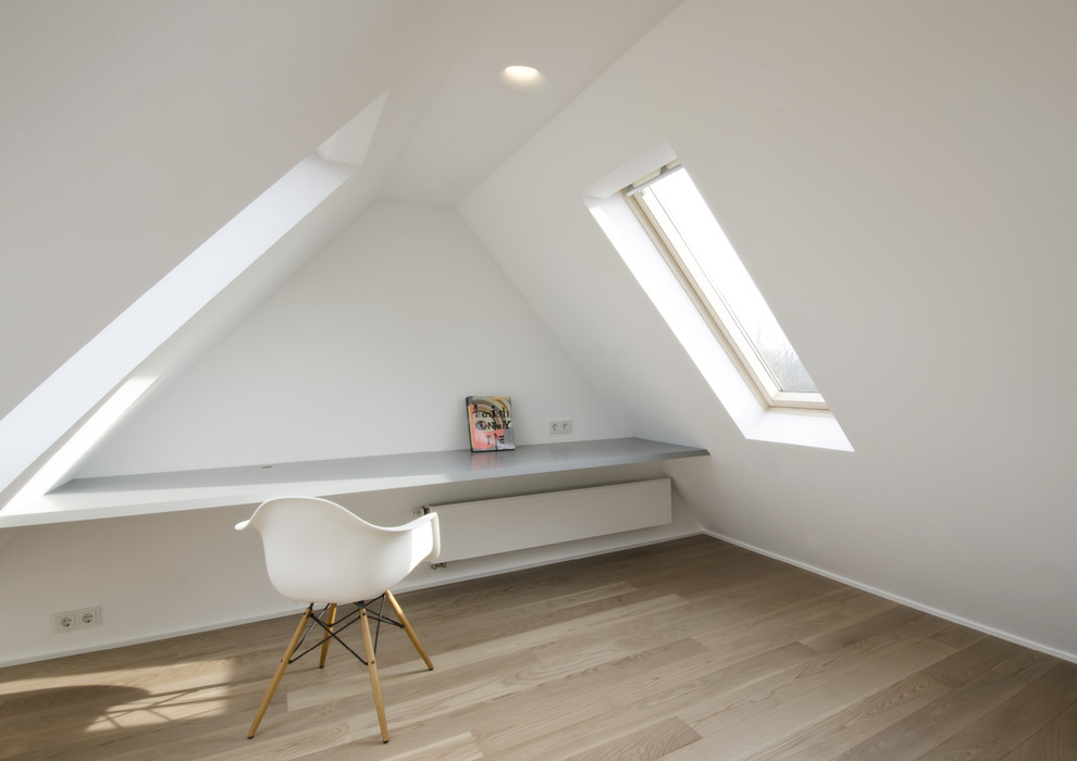 Foto di un piccolo ufficio minimalista con pareti bianche, parquet chiaro e scrivania incassata