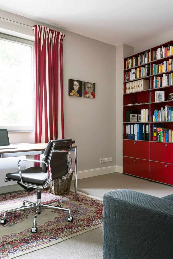 Kleines Modernes Arbeitszimmer ohne Kamin mit grauer Wandfarbe, Teppichboden, freistehendem Schreibtisch, grauem Boden und Arbeitsplatz in Hamburg