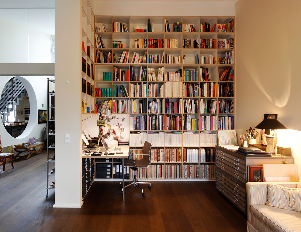Mittelgroßes Modernes Lesezimmer ohne Kamin mit beiger Wandfarbe, dunklem Holzboden und Einbau-Schreibtisch in Hamburg