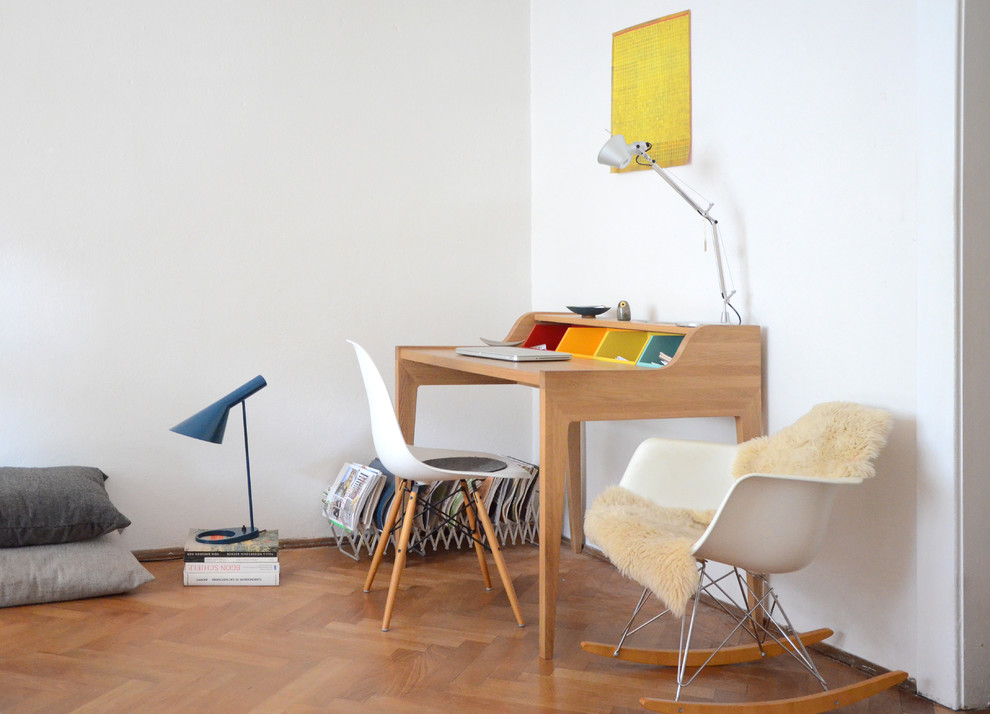 Kleines Modernes Arbeitszimmer ohne Kamin mit Arbeitsplatz, weißer Wandfarbe, braunem Holzboden und freistehendem Schreibtisch in Dresden