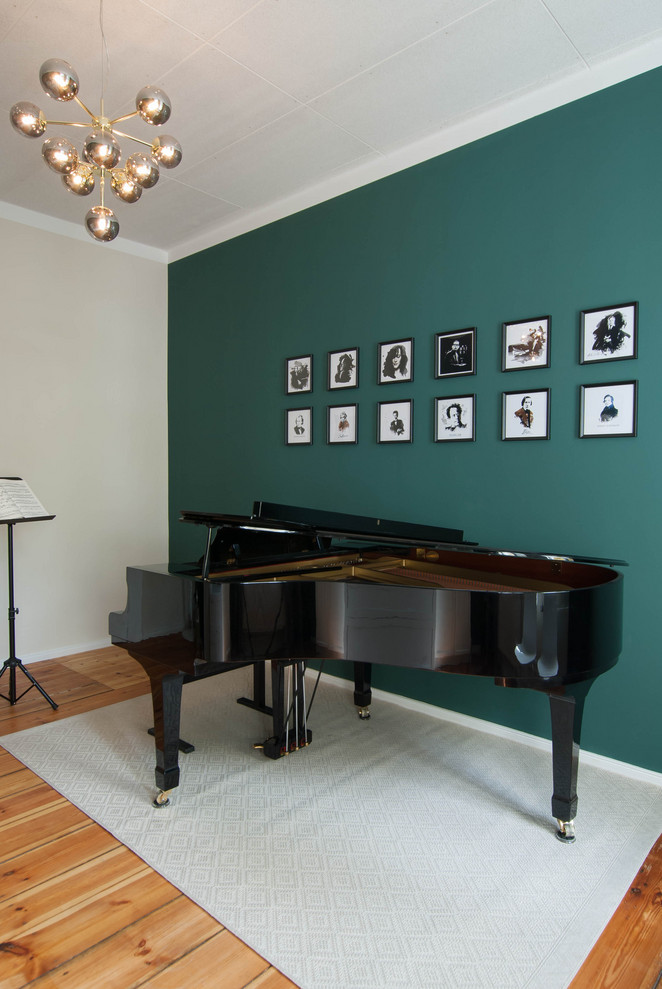 Immagine di uno studio tradizionale con pareti verdi e pavimento in legno massello medio