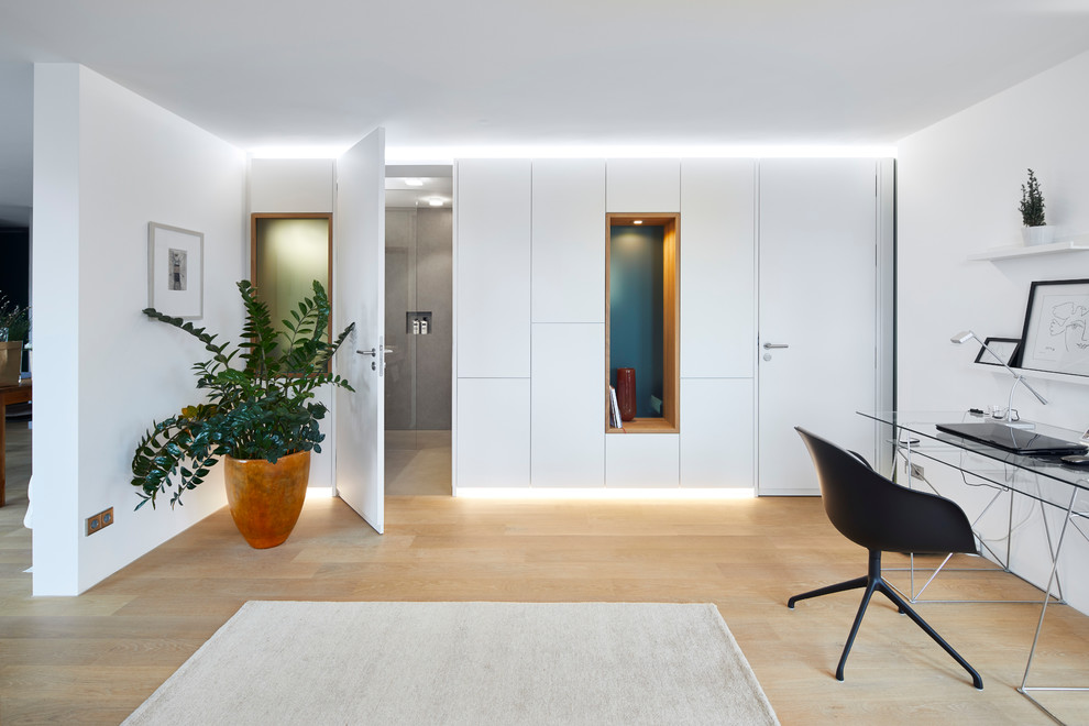 Idee per un grande ufficio design con pareti bianche, scrivania autoportante, pavimento marrone, parquet chiaro e nessun camino