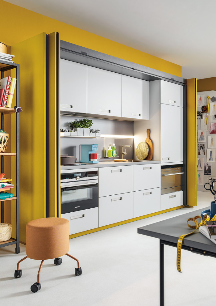 Idée de décoration pour un grand bureau atelier design avec un mur jaune et un sol blanc.