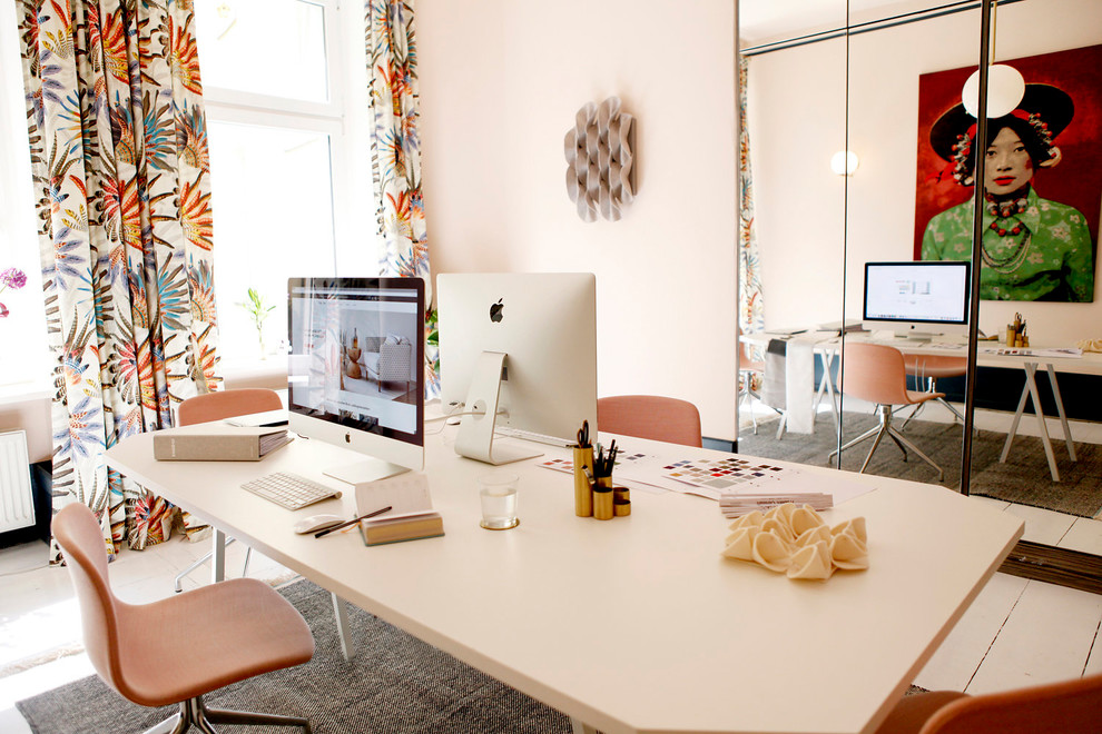 Mittelgroßes Eklektisches Arbeitszimmer mit Studio, rosa Wandfarbe, hellem Holzboden, freistehendem Schreibtisch und weißem Boden in Berlin