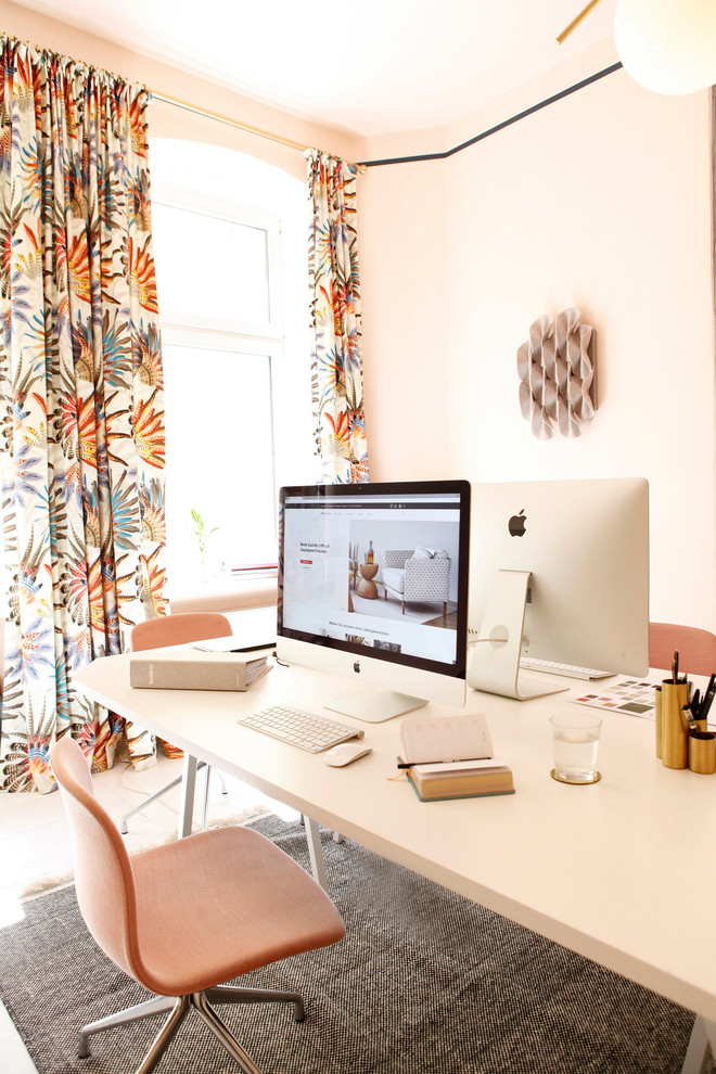 Bild på ett mellanstort eklektiskt hemmastudio, med rosa väggar, ljust trägolv, ett fristående skrivbord och vitt golv