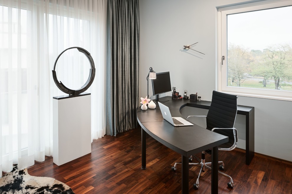 Foto di un grande ufficio design con parquet scuro, scrivania autoportante, pareti blu, pavimento marrone e nessun camino