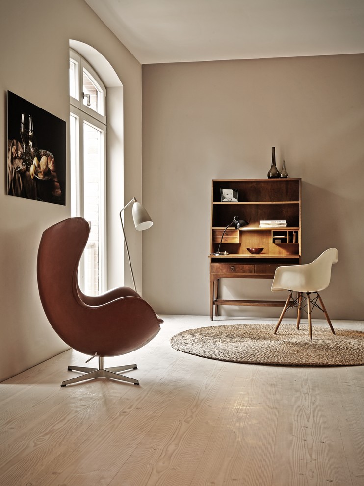 Imagen de despacho minimalista de tamaño medio sin chimenea con paredes beige, suelo de madera clara y escritorio independiente