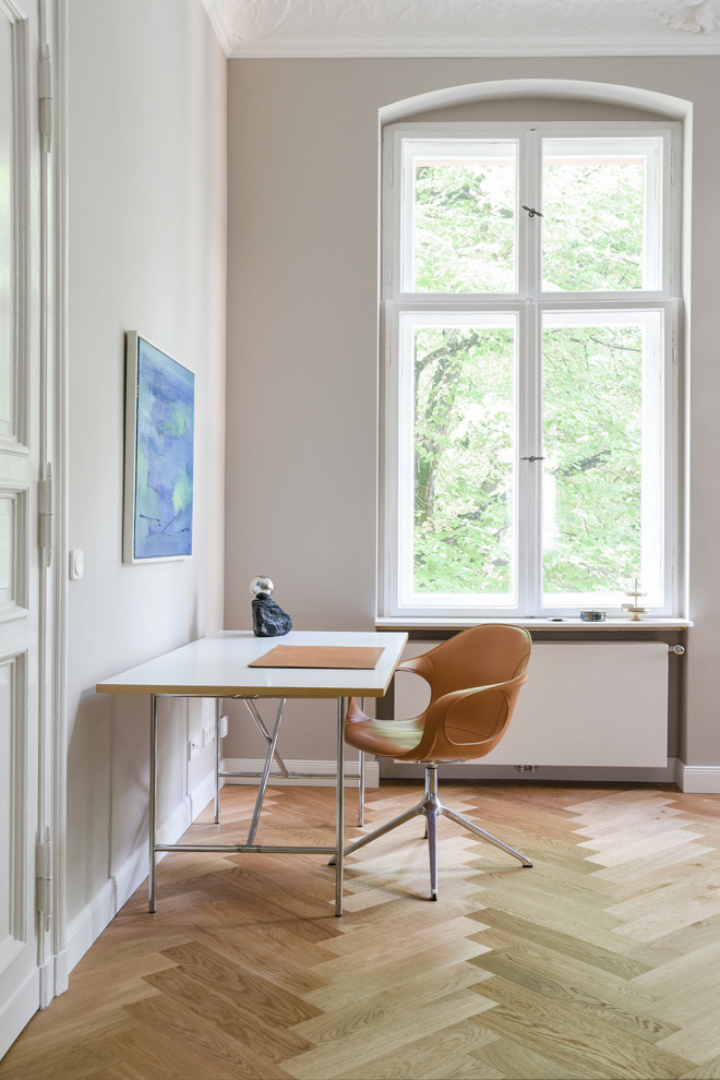 Foto de estudio contemporáneo grande sin chimenea con paredes grises, suelo de madera clara y escritorio independiente