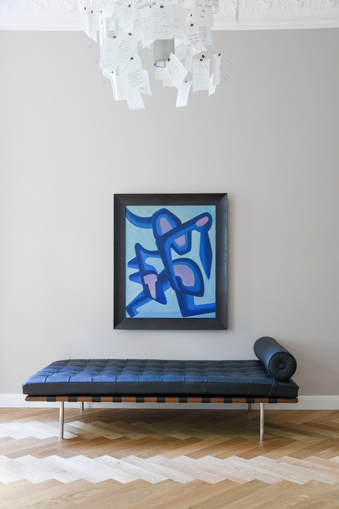 Photo of a large contemporary home studio in Berlin with grey walls, light hardwood flooring, no fireplace and a freestanding desk.