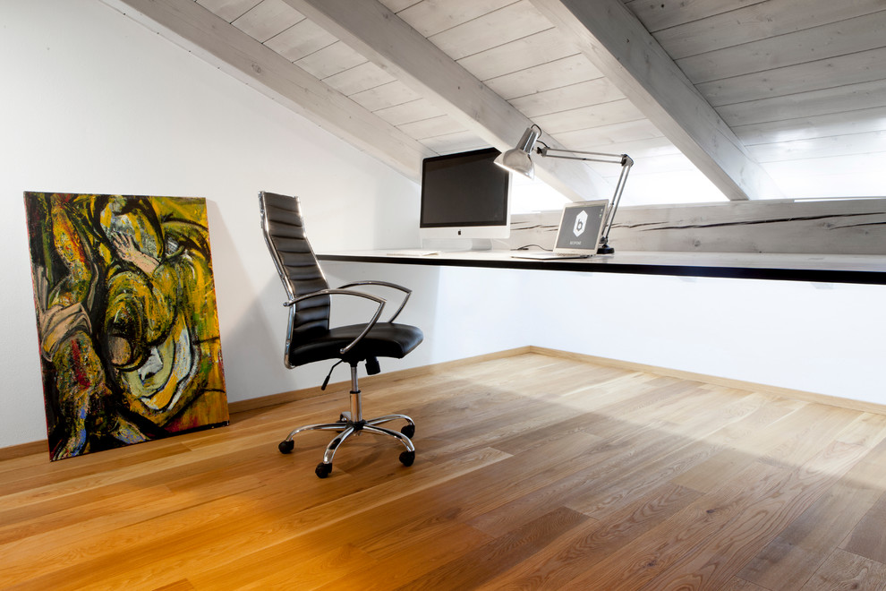 Idéer för ett stort minimalistiskt arbetsrum, med vita väggar, ljust trägolv, en öppen vedspis, en spiselkrans i metall och brunt golv