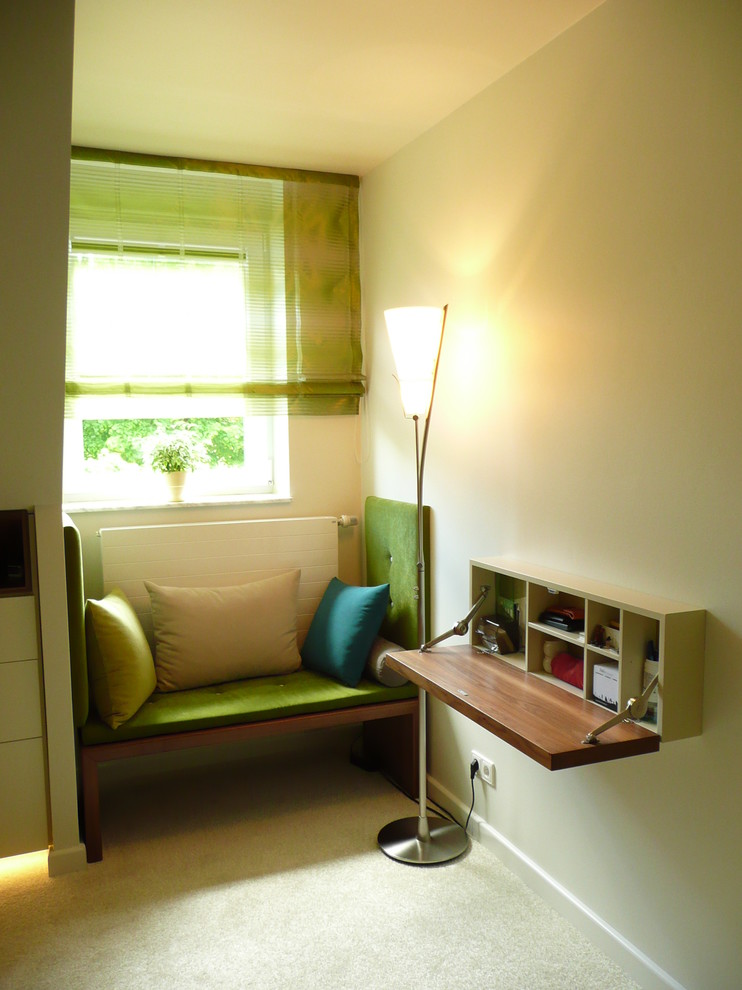 Exempel på ett litet modernt hobbyrum, med flerfärgade väggar, heltäckningsmatta och ett inbyggt skrivbord