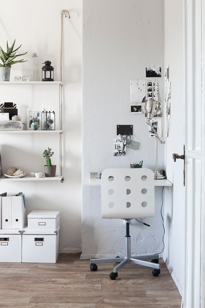 Idée de décoration pour un petit bureau nordique avec un mur blanc, un bureau intégré, un sol en bois brun et aucune cheminée.