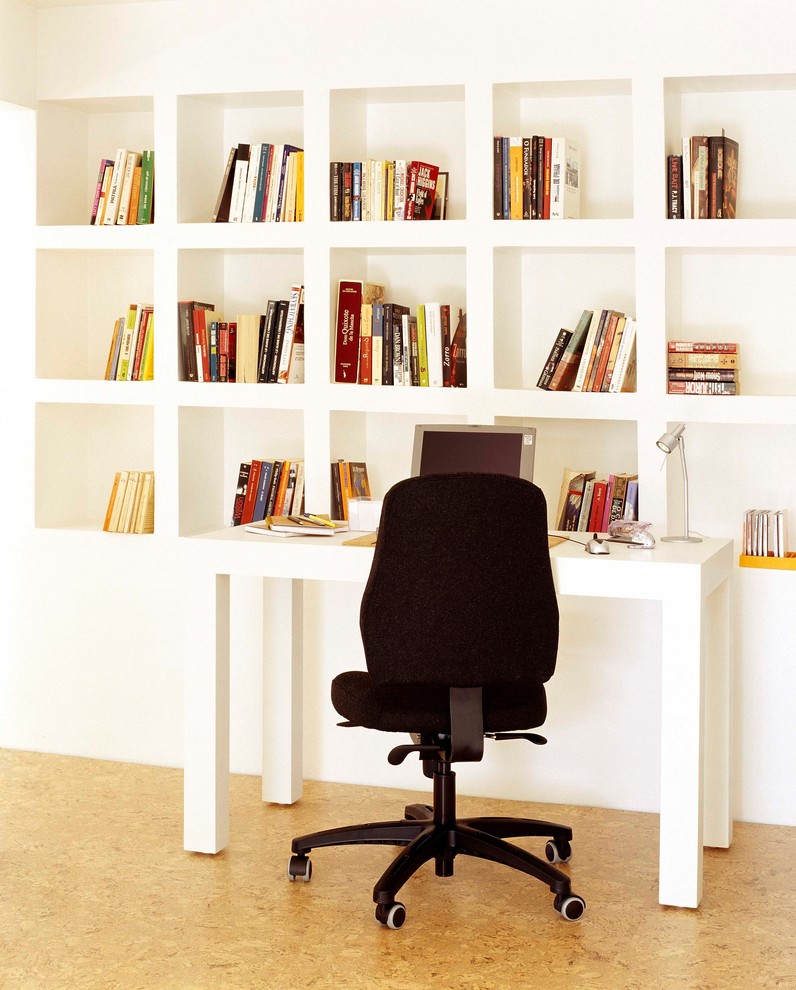 Kleines Skandinavisches Arbeitszimmer ohne Kamin mit Arbeitsplatz, weißer Wandfarbe, Korkboden, freistehendem Schreibtisch und braunem Boden in Sonstige