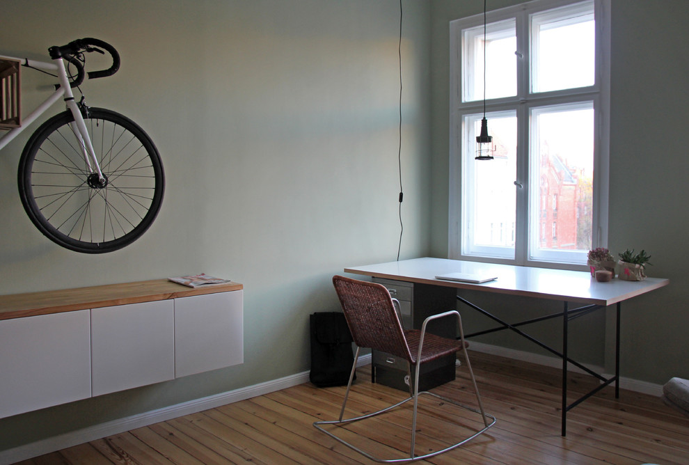 Arbeitszimmer mit Arbeitsplatz, grüner Wandfarbe, hellem Holzboden und freistehendem Schreibtisch in Berlin