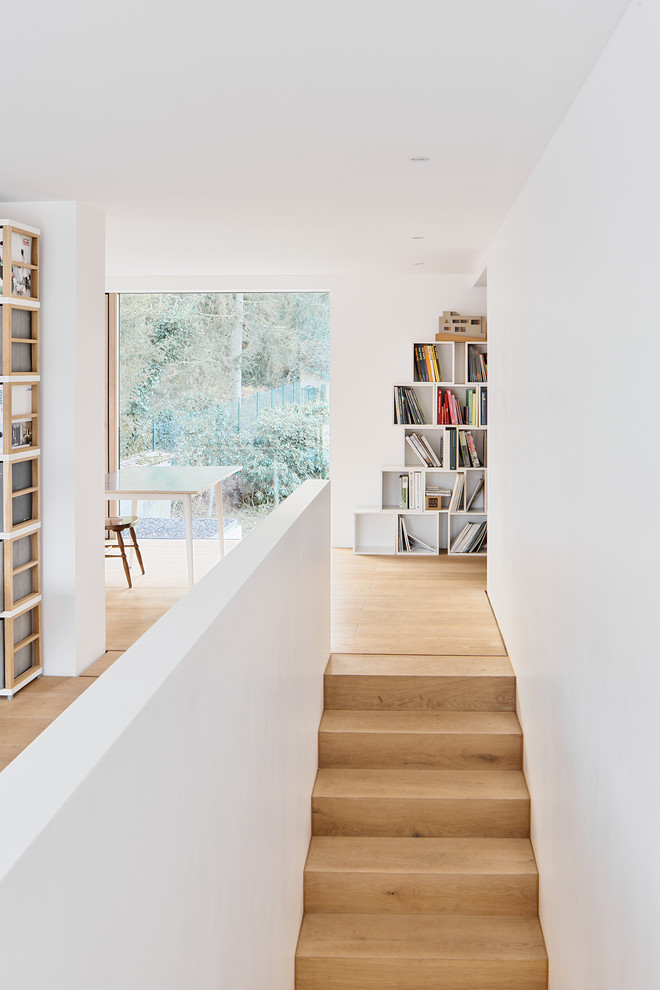 Foto de despacho minimalista sin chimenea con paredes blancas, suelo de madera clara, escritorio independiente y suelo beige