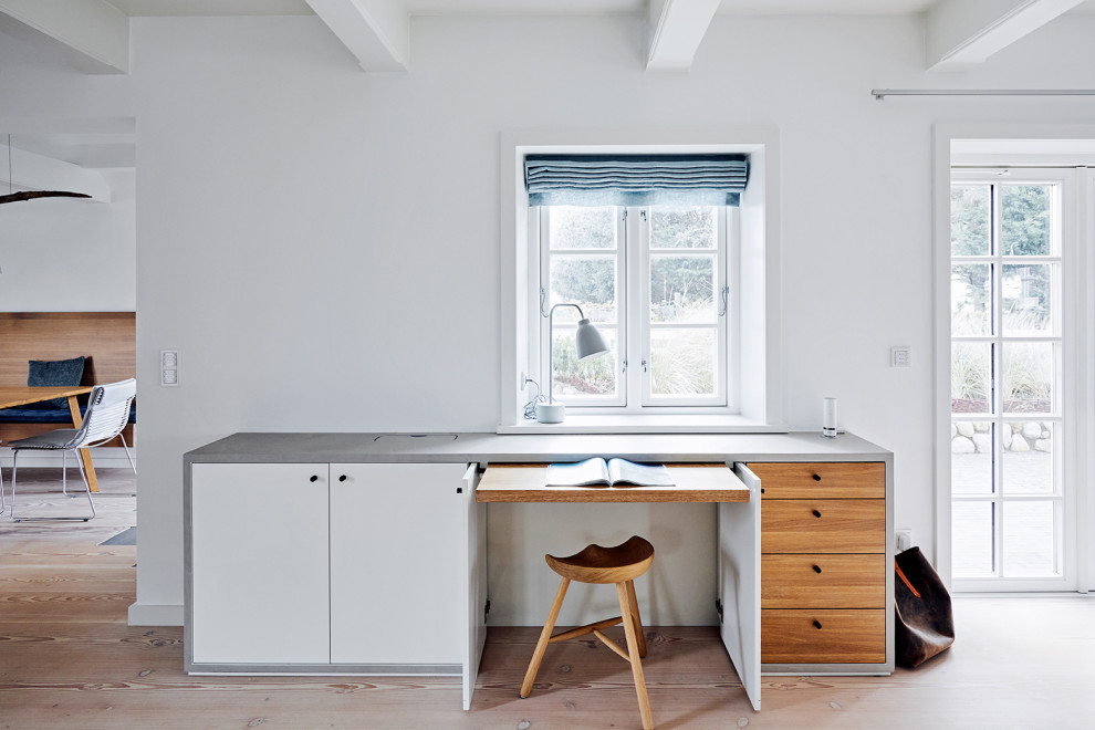 Cette image montre un bureau design avec un mur blanc, parquet clair, un bureau intégré, un sol beige et poutres apparentes.