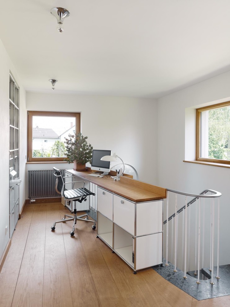 Ispirazione per un ufficio minimal con pareti bianche, pavimento in legno massello medio e scrivania incassata