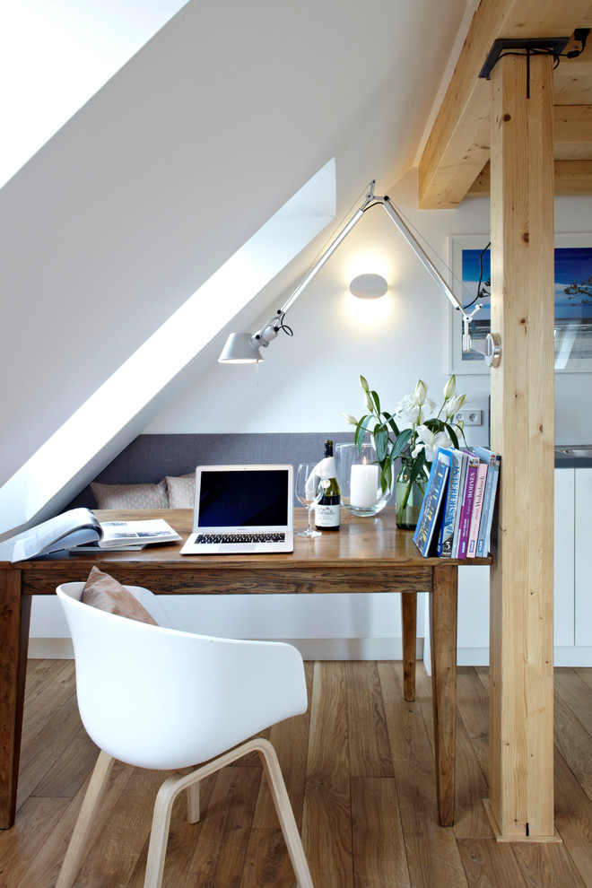 Idéer för små funkis hemmabibliotek, med vita väggar, mellanmörkt trägolv och ett fristående skrivbord
