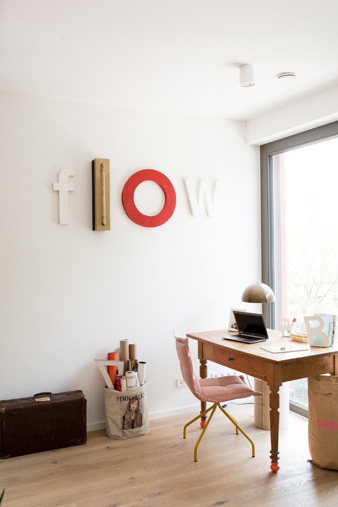 Ejemplo de despacho bohemio pequeño sin chimenea con paredes blancas, suelo de madera clara, escritorio independiente y suelo marrón