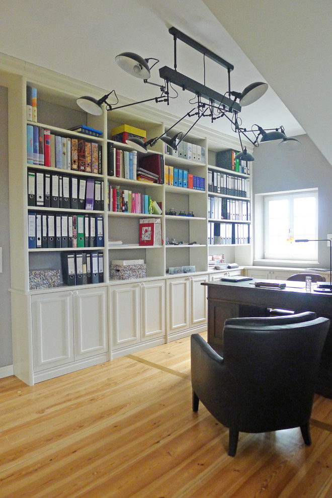 Foto di un grande ufficio tradizionale con pareti bianche, pavimento in legno massello medio, nessun camino e scrivania autoportante