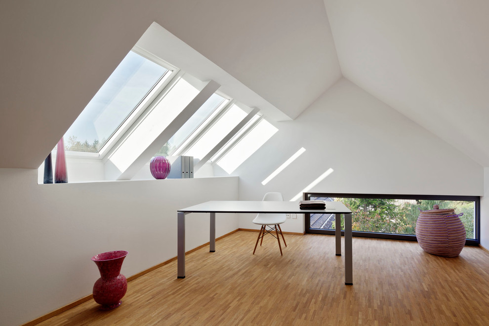 Источник вдохновения для домашнего уюта: большое рабочее место в современном стиле с белыми стенами, полом из бамбука и отдельно стоящим рабочим столом без камина