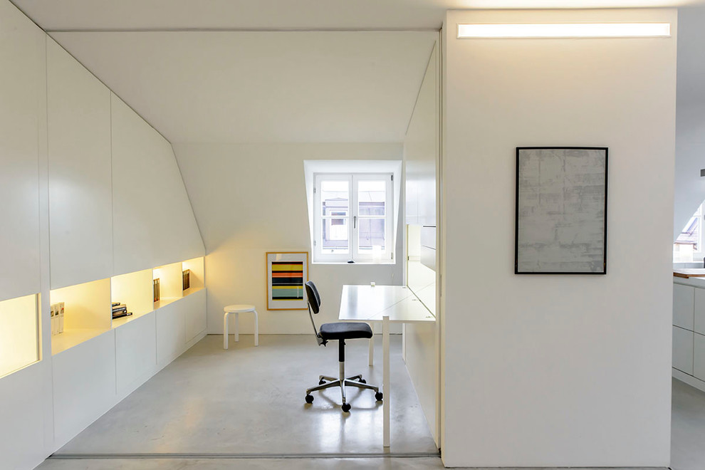 Imagen de despacho minimalista pequeño con paredes blancas, suelo de linóleo y escritorio empotrado