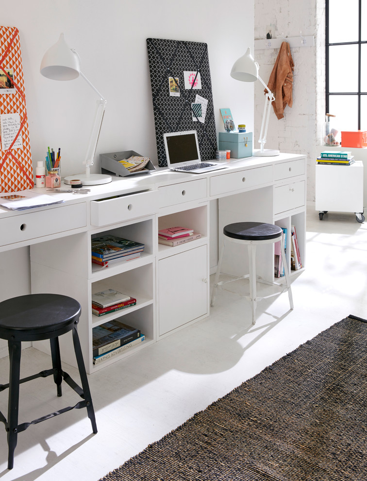 Scandinavian study in Hamburg with white walls, a built-in desk, light hardwood flooring and no fireplace.