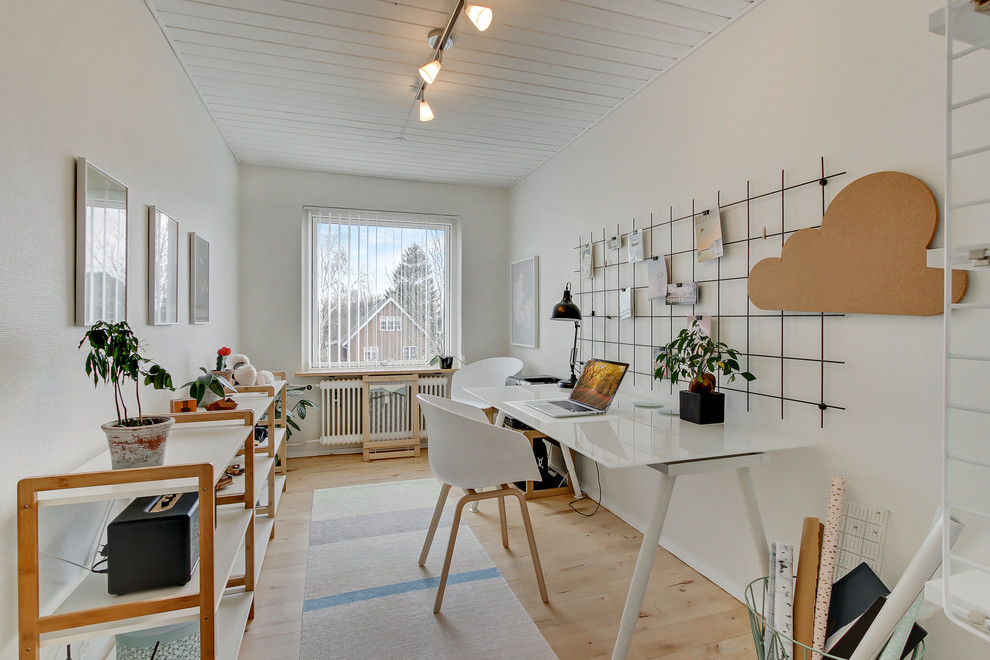 Пример оригинального дизайна: домашняя мастерская среднего размера в скандинавском стиле с белыми стенами, светлым паркетным полом и отдельно стоящим рабочим столом без камина