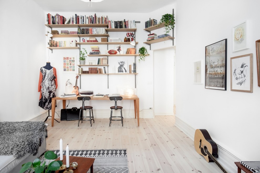 Exempel på ett mellanstort nordiskt hemmastudio, med vita väggar, ljust trägolv och ett fristående skrivbord