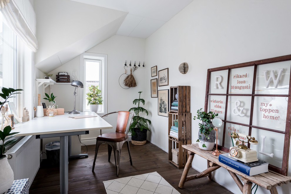 Mittelgroßes Industrial Arbeitszimmer ohne Kamin mit Arbeitsplatz, weißer Wandfarbe, dunklem Holzboden und freistehendem Schreibtisch in Göteborg