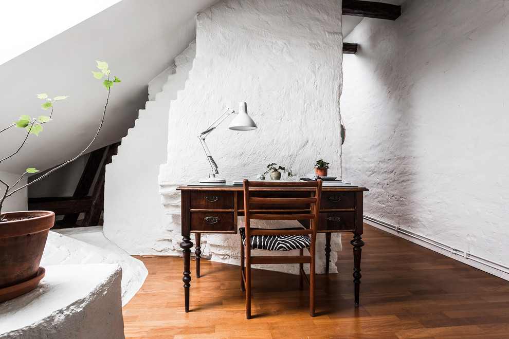 Idéer för mellanstora skandinaviska arbetsrum, med vita väggar, mellanmörkt trägolv och ett fristående skrivbord